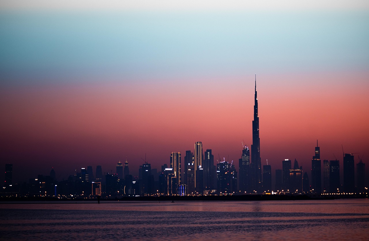 Dubai skyline silhouetted against a pink and blue dusk